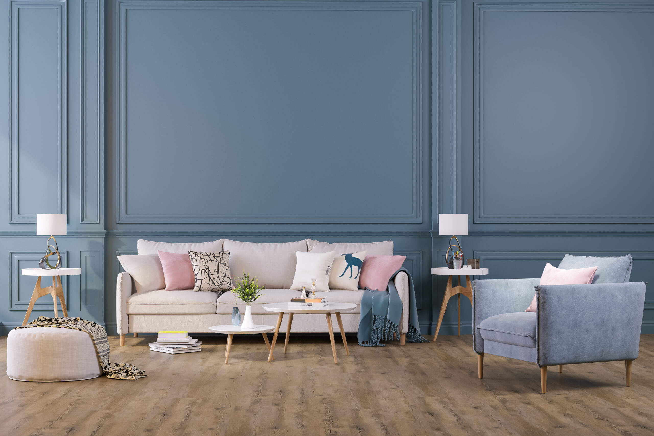 Salon classique chic avec murs en bleu pastel RAL 5024 et moulures, canapé beige, fauteuil velours et coussins rose poudré